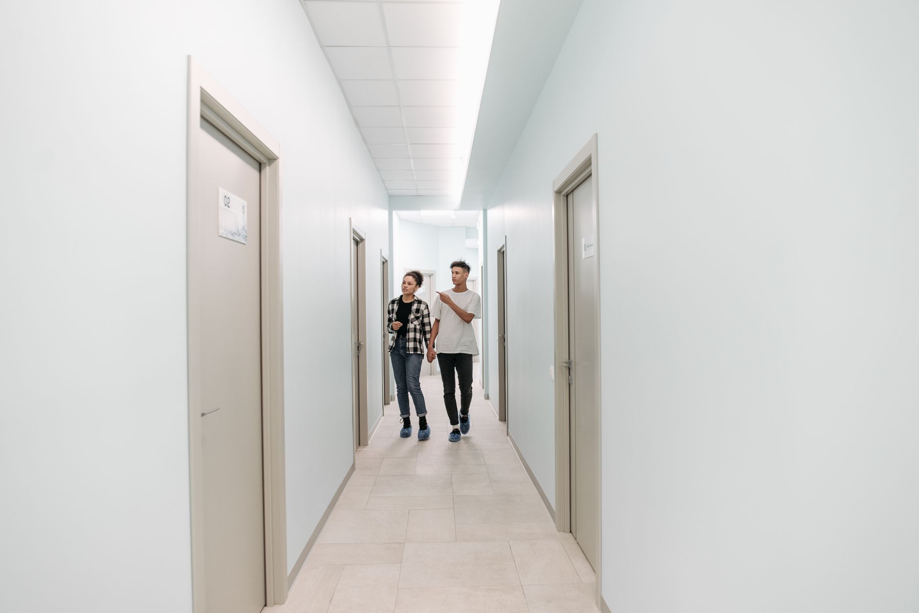 Corredor claro de uma clínica, com várias portas de consultório
